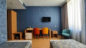 Habitación con mesa, sillas y pared azul. en Hotel DownTown Avlabari en Tiflis