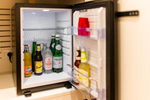 um frigorífico aberto cheio de garrafas de cerveja em Arringo - Stay comfy em Conversano