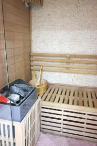 eine Sauna mit einer Holzbank und einem Eimer in der Unterkunft Capsule 90's - Jacuzzi - Sauna - Flipper - Billard - Netflix - Nintendo Switch & Jeux - in Mons