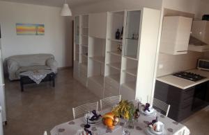 ロゼート・デッリ・アブルッツィにあるDonizetti Apartment 8のテーブル付きの部屋、棚付きのキッチンが備わる客室です。