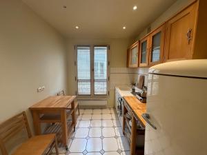 eine Küche mit einem Tisch und einem Kühlschrank in der Unterkunft 70 sqm apartment in 75008 Paris in Paris