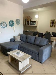 a living room with a blue couch and a table at Panoramic apartment in Shkodër