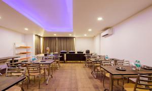 a dining room with tables and chairs and a purple ceiling at Treebo Trend Noida Express in Noida