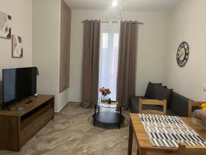 a living room with a couch and a tv at Elaionas Apartments 2 in Riglia