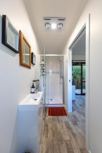 een badkamer met een douche en een witte wastafel bij Country Nirvana in Pataua