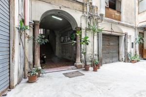 an entrance to a building with potted plants at Teatro Massimo Central Elegant Apartment x5 in Palermo