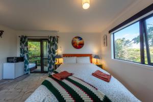 um quarto com uma cama e uma grande janela em Country Nirvana em Pataua