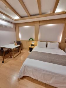a bedroom with a large bed and a table at LEX Tourist Hotel in Seoul