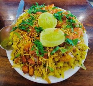 un plato de comida con arroz y pepinillos en una mesa en Hotel Alpine, en Jaipur