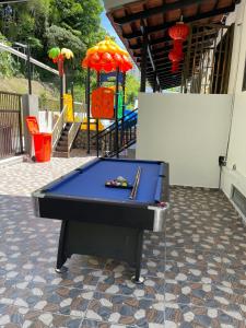 a blue ping pong table on a patio with a playground at 15PAX 3 BR, Kids Swimming Pool, Pool table, BBQ near Spice ARENA, Airport Penang in Bayan Lepas