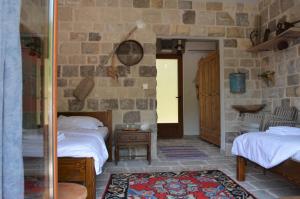 a bedroom with two beds and a stone wall at Markovic Winery and Estate apartments in Cetinje