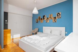 Cama blanca en habitación con pared azul en Prime Location in City Center I The Blue Art Spot, en Sofía