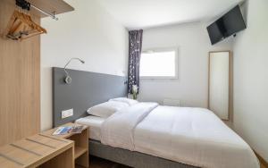 a bedroom with a large white bed and a window at Hotel Cerise Nancy in Nancy