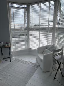 a living room with a white couch and large windows at Shoreline in St Ives