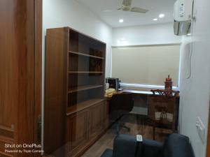 uma sala de estar com uma secretária e uma estante de livros em Modern Room(R1) in Heart of City em Nova Deli