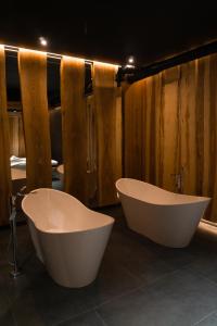 two white bath tubs in a bathroom with wooden walls at Hostel VinoGrad in Haysyn +33 photos