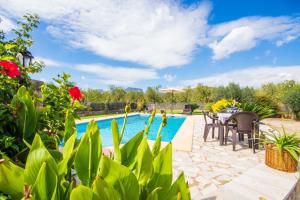 um pátio com uma mesa e cadeiras e uma piscina em Puri em Lloseta