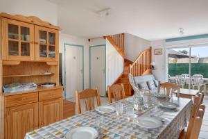 uma cozinha e sala de jantar com mesa e cadeiras em Maison confortable et familiale pour 6 personnes em Sarzeau