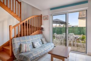 a living room with a couch and a table at Maison confortable et familiale pour 6 personnes in Penvins