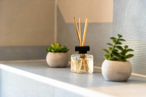 two potted plants and a bottle of perfume on a counter at Villa Luce in Komiža
