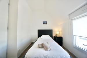 a bedroom with a bed with a towel on it at Cabine de plage n°2 *50m de la plage* in Ploemeur
