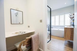 y baño con espejo, lavabo y bañera. en Beautiful boutique feel centrally located en Hereford