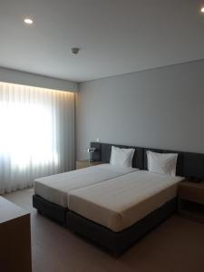 Un dormitorio con una cama grande y una ventana en Hotel Imperial, en Aveiro