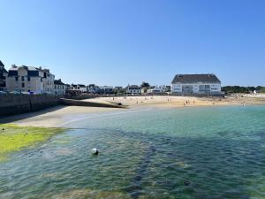 a beach with a body of water and a beach at Cabine de plage n°2 *50m de la plage* in Ploemeur