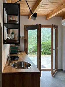 a kitchen with a sink and a large window at Sa Guardia de Ferricci in Solanas