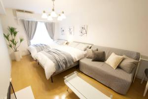 sala de estar con 2 camas y sofá en Generous Forest 201, en Tokio