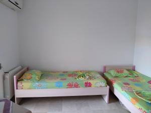 um quarto com 2 camas individuais e lençóis coloridos em Appartement Vue Sur Mer Turquoise em Mahdia