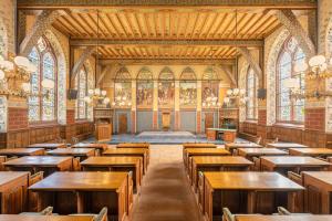 a large room with wooden tables and benches at Hotel Staatsman in Zwolle