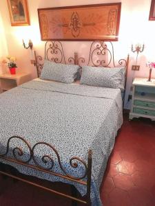 1 dormitorio con 1 cama con cabecero de metal y almohadas en un'angolo incantato en Florence