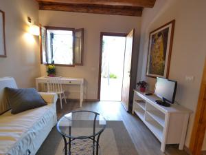 ein Wohnzimmer mit einem Sofa und einem TV in der Unterkunft Belvilla by OYO Ventimiglia in Ventimiglia