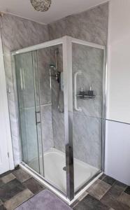 a shower with a glass door in a bathroom at Ligford Cottage 