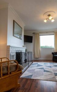 a living room with a fireplace and a window at Ligford Cottage in Strabane
