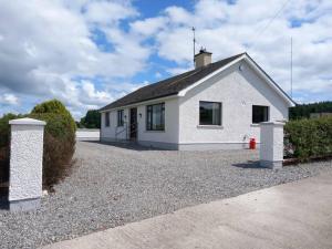 a white house with a gravel driveway at Ligford Cottage in Strabane