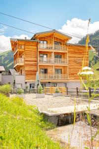 duży drewniany budynek z balkonem w obiekcie Apart-Hotel Laurus Lech w Lech am Arlberg