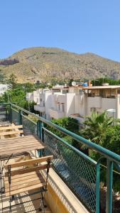 a balcony with tables and a view of a city at Àrima Mondello Apartment in Mondello