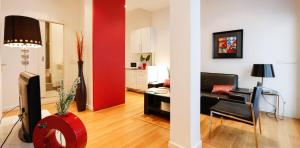 Precioso apartamento en Calle Iriarte في مدريد: إطلالتان على غرفة معيشة مع جدار احمر