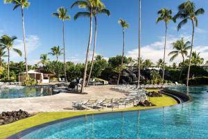 einen Pool in einem Resort mit Palmen in der Unterkunft Marriott’s Waikoloa Ocean Club in Waikoloa