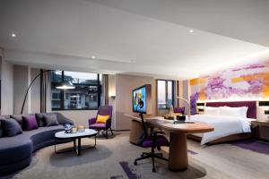 ein Hotelzimmer mit einem Kingsize-Bett und einem Schreibtisch in der Unterkunft Hampton by Hilton Hangzhou West Lake in Hangzhou