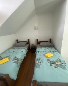 two twin beds in a room with white walls at Hotel Lane in Kraljevo
