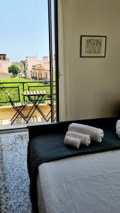 two towels on a bed in a room with a balcony at Àrima Mondello Apartment in Mondello