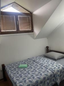 a small bedroom with a bed and a window at Hotel Lane in Kraljevo