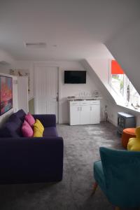 a living room with a blue couch and a kitchen at St Duthus Hotel Apartment in Tain