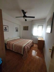 a bedroom with a bed and a ceiling fan at La casa de Emma in Piles