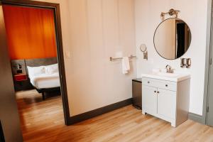 a bathroom with a sink and a mirror and a bed at Hotel Historique et Manoir Route 66 in Saint-Victor +57 photos