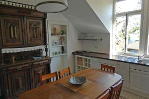 eine Küche mit einem Holztisch mit Stühlen und einem Fenster in der Unterkunft Herrschaftliches Apartment in historischer Villa in Hanau am Main