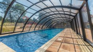 a swimming pool under an archway in a building at Apartamenty Sun & Snow Baltic Garden in Sztutowo
